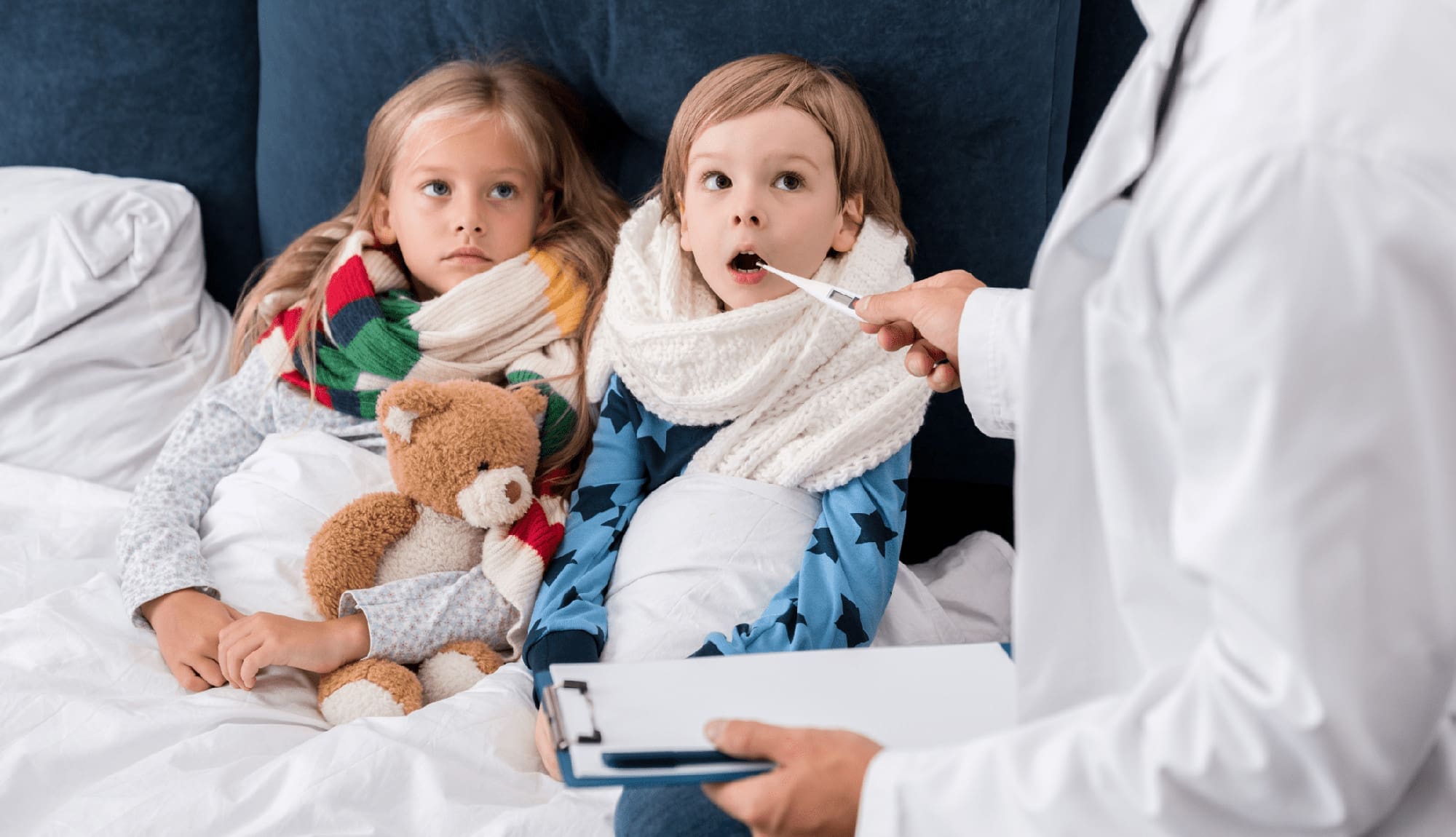 Mother caring for her sick child during flu season with tissues and a thermometer in hand