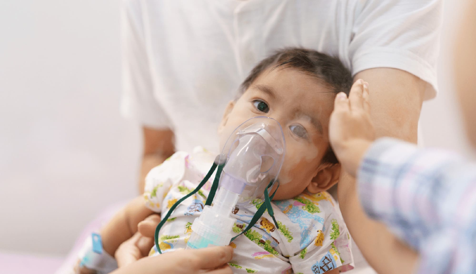 Asian little baby boy is is treated respiratory problem with vapor nebulizer in hospital admit room.