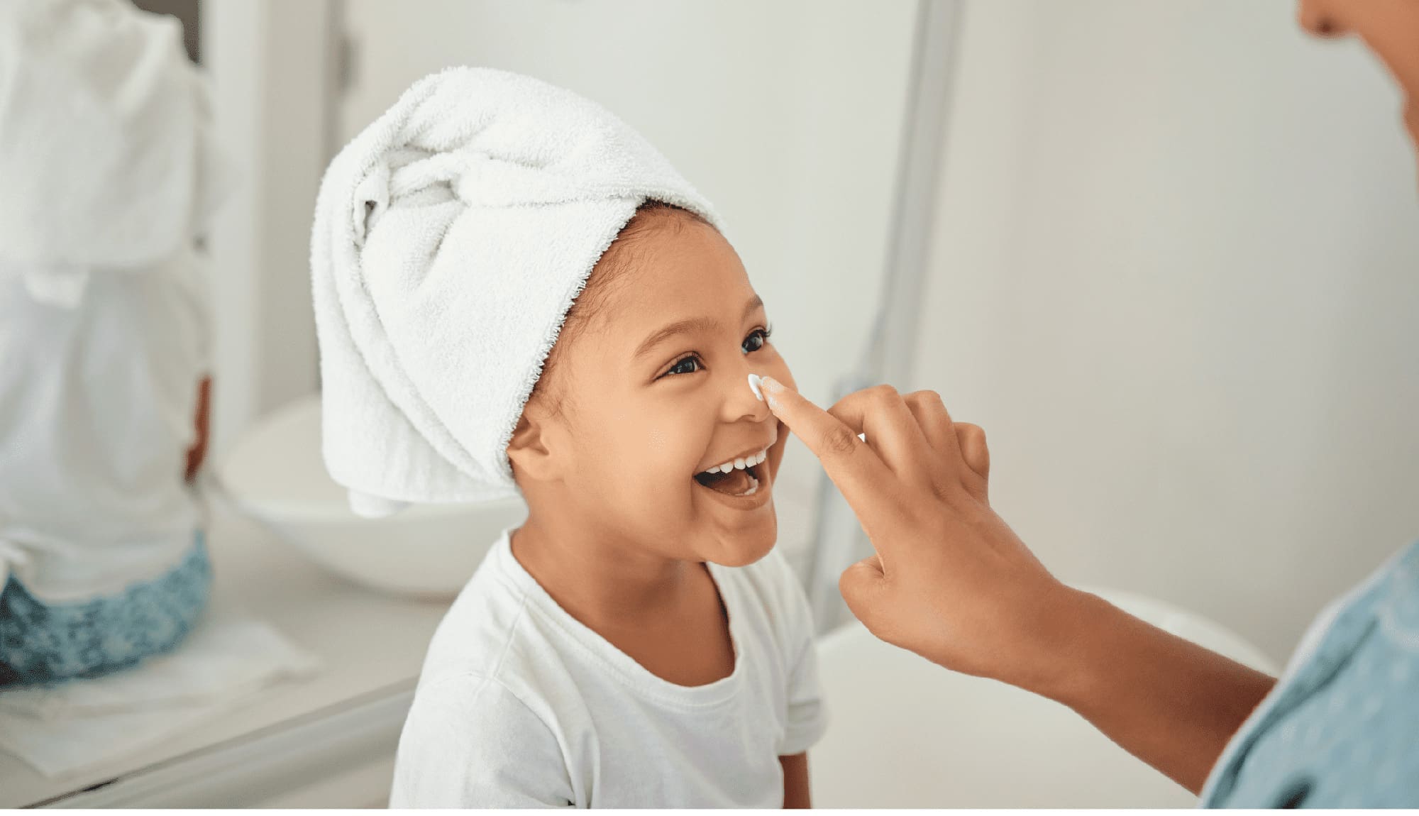 Skincare, cream and girl child at home with mother with a happy smile in a bathroom.
