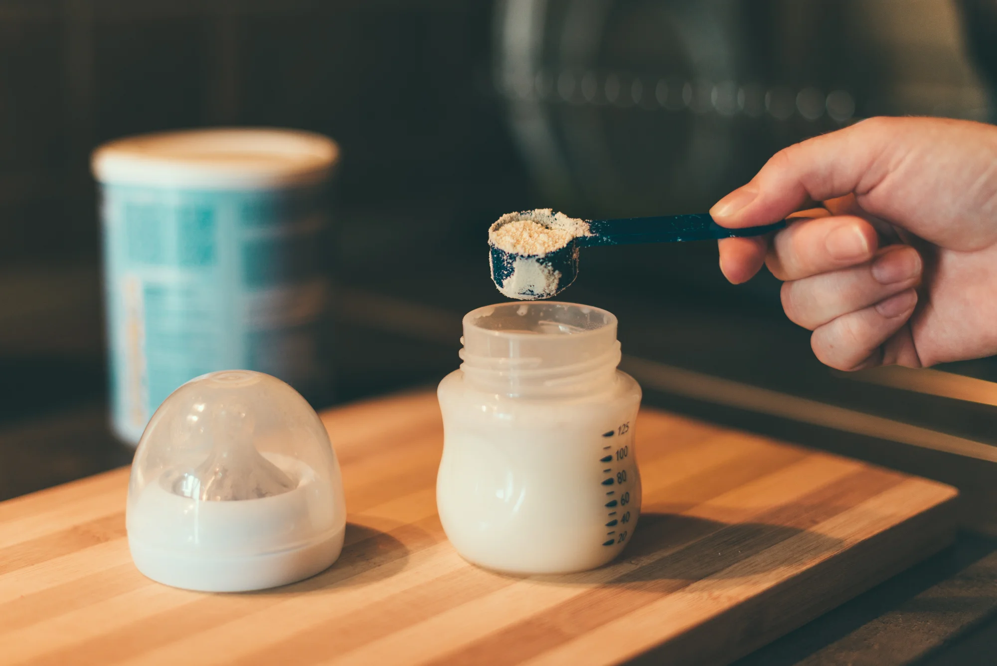 Mother supplementing breastfeeding with formula bottle at home, newborn care guidance from Happy Bun Pediatrics McKinney TX